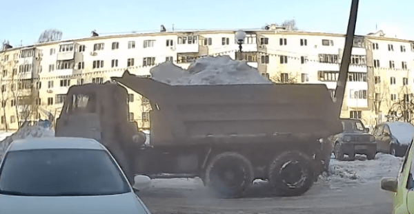 В Нижнем Новгороде груженный снегом Камаз уронил столб на припаркованный автомобиль (видео)